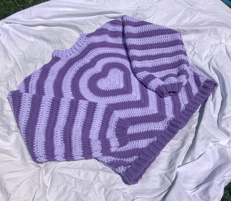 May include: A purple and white striped crocheted sweater with a heart pattern.