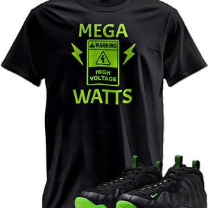 May include: Black t-shirt with neon green text and graphics that read "MEGA WARNING HIGH VOLTAGE WATTS." The shirt is paired with black and neon green athletic shoes.