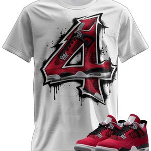 May include: White t-shirt featuring a red and black graphic of a sneaker-themed "4" design with black paint splatter. A pair of red and black sneakers are displayed below the shirt.