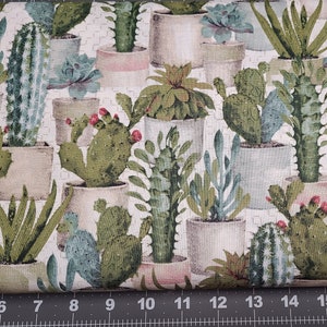 May include: A white fabric with a repeating pattern of various green succulents and cacti in pots. The pots are a mix of brown, white, and pink.
