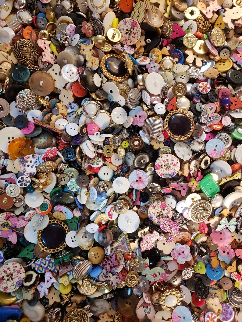 May include: A large collection of colorful buttons in various shapes, sizes, and materials. The buttons are a mix of plastic, metal, wood, and fabric. Some buttons have floral patterns, while others have geometric designs. There are also buttons with animal motifs, such as butterflies and birds.