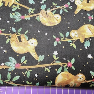 Könnte beinhalten: Schwarzer Stoff mit einem sich wiederholenden Muster von Faultieren, die an Ästen hängen. Die Faultiere sind braun und gelb mit weißen Sternen im Hintergrund.