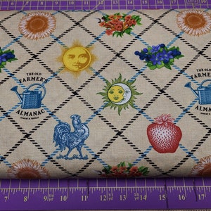 May include: Beige fabric with a repeating pattern of a sun, a rooster, a strawberry, a watering can, a sunflower, and a bouquet of flowers. The fabric also has a black and blue diamond pattern. The text "The Old Farmer's Almanac" is repeated throughout the fabric.