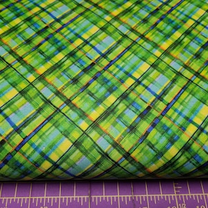 以下が含まれることがあります： 緑、青、黄、オレンジの格子柄の布地で、筆のタッチのような模様が施されています。