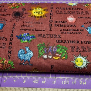 May include: A red fabric with a vintage gardening theme. The fabric features text that reads "Gardening Calendar", "The Old Farmer's Almanac", "Folklore", "Home Remedies", "A Calendar of the Heavens", "Weather Forecasts", and "Astronomy". The fabric also features illustrations of a sunflower, a rooster, a watering can, and a sun and moon.