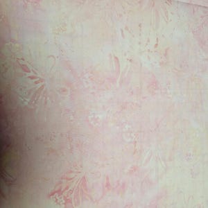 Pode incluir: Um tecido rosa claro e creme com um padrão floral e borboleta sutil. O tecido tem um efeito suave como aquarela.