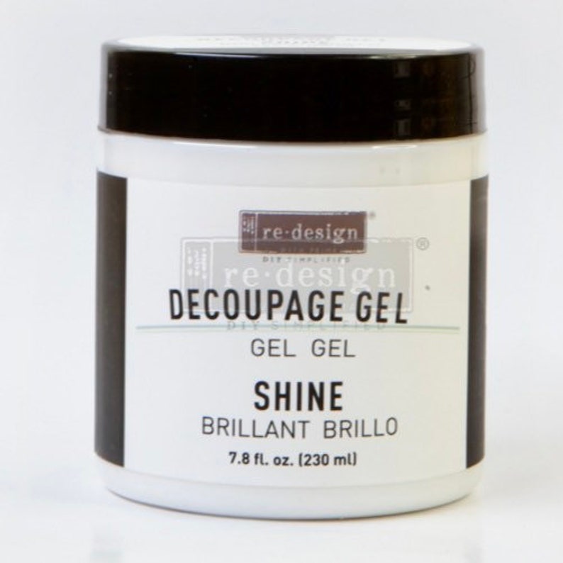 K&ouml;nnte beinhalten: Ein wei&szlig;es Glas re-design Decoupage Gel mit schwarzem Deckel. Das Etikett lautet "re-design Decoupage Gel, Gel Gel, Shine, Brillant Brillo, 7.8 fl. oz. (230 ml)"