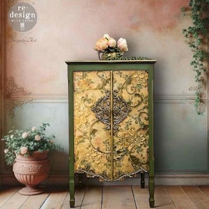 Puede incluir: Un mueble verde y dorado con dise&ntilde;os florales y herrajes ornamentados. El mueble tiene dos puertas con un patr&oacute;n floral detallado y un cierre de metal decorativo. La parte superior del mueble tiene un peque&ntilde;o jarr&oacute;n con flores. Se ven las palabras "re-design with prima".
