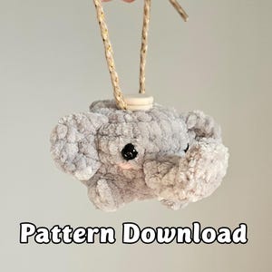 May include: A gray, plush elephant ornament with black eyes and a beige rope for hanging. The text "Pattern Download" is displayed in a black font at the bottom of the image. The elephant is made of a soft, textured material.