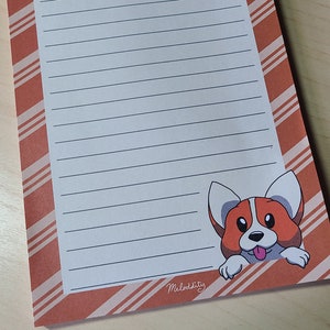 May include: A lined notepad with a red and white striped cover. A cartoon corgi dog peeks out from the bottom right corner of the notepad. The notepad has the word "Meloddisty" printed on the bottom right corner.