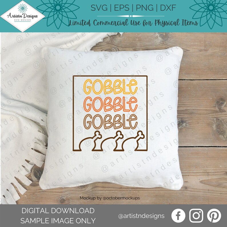 K&ouml;nnte beinhalten: Ein wei&szlig;es Kissen mit dem Text "GOBBLE GOBBLE GOBBLE" in orange, gelben und braunen Buchstaben. Unter dem Text befinden sich drei braune Truthahnkeulen. Das Kissen liegt auf einer Holzoberfl&auml;che.
