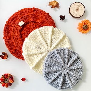 Peut inclure: Trois chapeaux en crochet de couleurs et de motifs différents. Le plus grand chapeau est orange, le chapeau du milieu est blanc et le plus petit chapeau est gris.