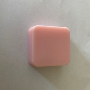 May include: A rectangular bar of light pink soap.