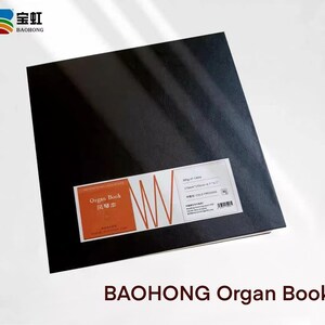 May include: A black, square, hardcover book with the text "Organ Book" in red and Chinese characters on the front cover. The book is labeled "200g/m&sup2; - 140S" and "170mm*170mm - 4.2"*4.2" - 中性 - COLD PRESSING" on the right side. The book is on a white surface.