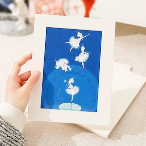 May include: A white picture frame with a blue background and a white illustration of four ballerinas dancing. The ballerinas are wearing white tutus and have red shoes. The background is a blue sky with white stars.
