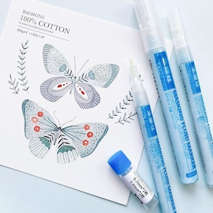 May include: Three blue masking fluid marker pens with the text "MASKING FLUID MARKER FOR WATERCOLOR, GOUACHES AND INKS" and a small blue bottle with the text "0.7mm*2枚 3.0mm*2枚".