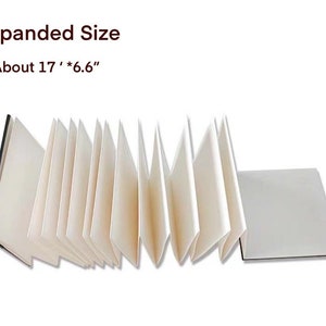 May include: A white accordion-style sketchbook with a black cover, expanded to show the pages. The sketchbook is about 17 inches by 6.6 inches.