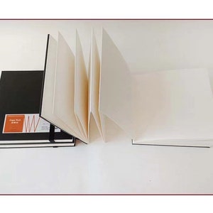 May include: A black sketchbook with the text "Organ Sketch" and a red and white graphic design. The sketchbook is open to reveal blank white pages.