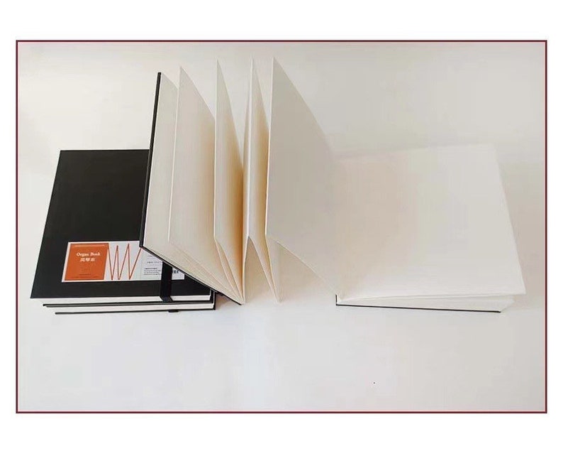 May include: A black sketchbook with the text "Organ Sketch" and a red and white graphic design. The sketchbook is open to reveal blank white pages.