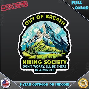 May include: A sticker with a mountain scene and the text "Out of Breath Hiking Society Don't Worry, I'll Be There In A Minute". The sticker is white with a black outline and has a green, blue, and white mountain scene with a lake in the foreground. The text is in black and green.
