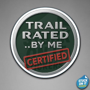 May include: A round sticker with a silver border and a dark green center. The text "TRAIL RATED ..BY ME" is in white, with "CERTIFIED" in a red rectangle at the bottom. A small blue sticker with the text "STUCK ON IT STICKERS" is in the bottom right corner.