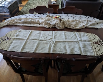 This is an antique linen table runner with crocheted edges.