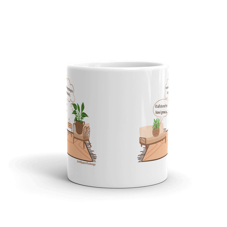 May include: White ceramic mug with a brown and green illustration of two potted plants on a rug. The text "It almost seems like I grow..." is in a thought bubble above one of the plants.