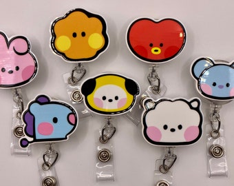 May include: Seven colorful cartoon character badge reels with clear plastic retractable cords. The characters are a pink bunny, an orange cloud, a red heart, a blue bear, a yellow dog, a blue dinosaur, and a white cloud.