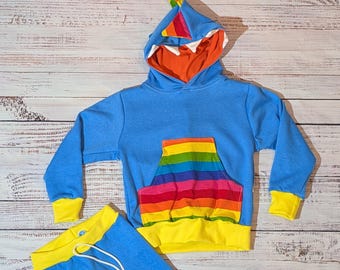 Sudadera con capucha y pantalones de dinosaurios azules y arcoíris.