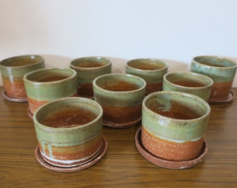 Rustic ceramic planters with catchers.  Top half green, bottom and catchers terracotta.