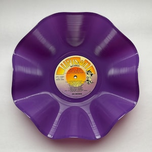 May include: A purple vinyl record bowl with a scalloped edge. The center label features the Uptown Records logo, the text Mary J. Blige What's the 411?, and a tracklist for Side One. The record has a glossy finish and a circular center hole.