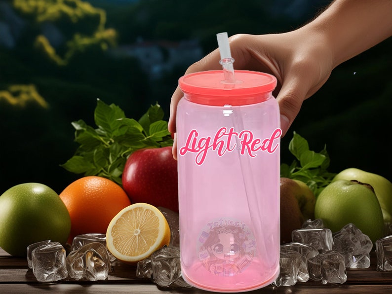 May include: A pink reusable tumbler with a red lid and a clear straw. The tumbler has the words "Light Red" printed on the side. The tumbler is surrounded by fruit and ice cubes.
