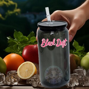 May include: A black reusable water bottle with a black lid and a clear straw. The bottle has the words "Black Dust" printed on it in pink letters. The bottle is surrounded by fruit and ice cubes.