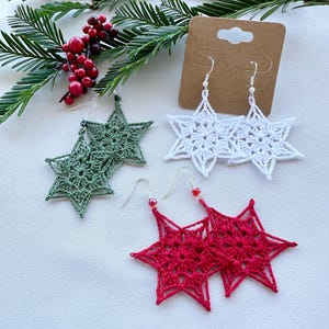 Puede incluir: Tres pares de pendientes de estrella de ganchillo. Un par es verde, un par es blanco y un par es rojo.