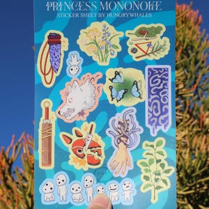 May include: A sticker sheet with illustrations from Princess Mononoke. The sheet includes images of a wolf, butterflies, and other characters and symbols from the film, set against a blue background. The text "PRINCESS MONONOKE" is at the top.
