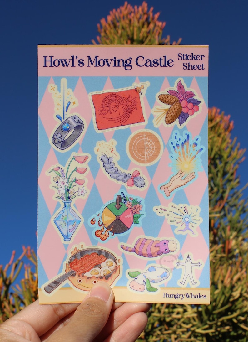 May include: A sticker sheet with illustrations from "Howl's Moving Castle." The sheet has a pink and blue diamond pattern background. Stickers include a ring, a red banner, a braid, a hand with light, a vase of flowers, a pan with food, and a cow.