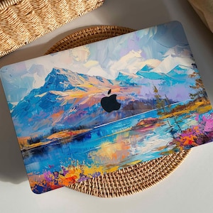Könnte beinhalten: Eine Laptop-Haut mit einem farbenfrohen abstrakten Gemälde einer Bergkette und einem See. Das Gemälde ist in einem Stil gehalten, der an den Impressionismus erinnert. Die Haut ist für einen Laptop mit einem Apple-Logo konzipiert.
