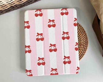 May include: A pink and white striped iPad case with a repeating pattern of red cherries. The cherries have a small green stem and leaf.