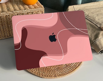 May include: A pink and brown laptop skin with abstract shapes and white lines. The Apple logo is visible in the center of the skin.