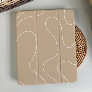 Op de afbeelding: Een beige tablethoes met een wit abstract ontwerp. De hoes heeft een klep.