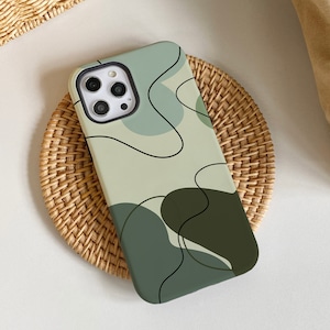 May include: A green, white, and black phone case with an abstract design. The case has a camera cutout and a raised lip around the edges.