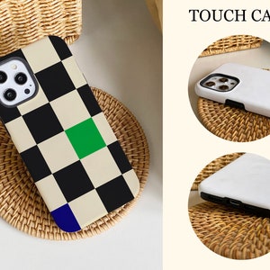K&ouml;nnte beinhalten: Eine schwarz-wei&szlig;e Schachbrett-Handyh&uuml;lle mit einem gr&uuml;nen und blauen Akzent. Die H&uuml;lle wird auf einer gewebten Oberfl&auml;che gezeigt. Der Text "TOUCH CASE" ist im Bild sichtbar.