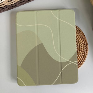 May include: A green and brown tablet case with an abstract design. The case has a three-piece design with a flap that covers the screen.