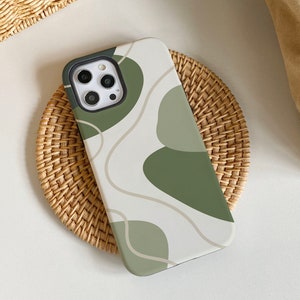 May include: A white phone case with a green abstract design. The case has a camera lens cutout and a white background.