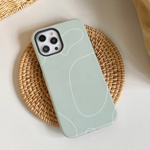 May include: A light green phone case with a white abstract design. The case has a raised camera bump and a black border around the camera lenses.