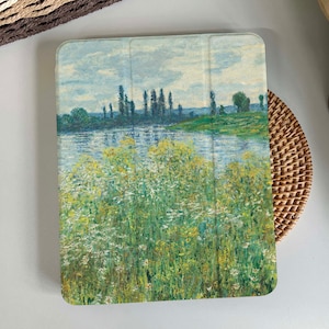 Puede incluir: Una pintura de paisaje blanca y azul con un río y árboles verdes en el fondo. El primer plano presenta un campo de flores amarillas y verdes.