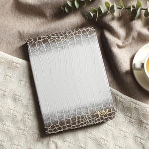 Puede incluir: Un juego de tres tazas de cerámica con un acabado moteado y mate. Las tazas son de color crema, gris claro y gris oscuro. Cada taza tiene un diseño simple y minimalista.