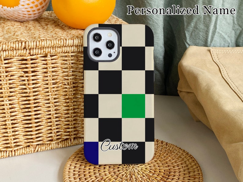 K&ouml;nnte beinhalten: Eine schwarz-wei&szlig;e Schachbrett-Handyh&uuml;lle mit einem gr&uuml;nen Quadrat und dem Wort "Custom" in wei&szlig;er Schrift. Die H&uuml;lle ist f&uuml;r ein Handy mit einer Kamerabuckel konzipiert.