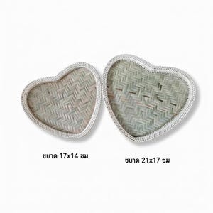 Puede incluir: Dos bandejas tejidas en forma de corazón. Las bandejas están hechas de material tejido verde claro y blanco. La bandeja más pequeña mide 17 cm x 14 cm, y la bandeja más grande mide 21 cm x 17 cm. Los bordes están ribeteados con un borde blanco.