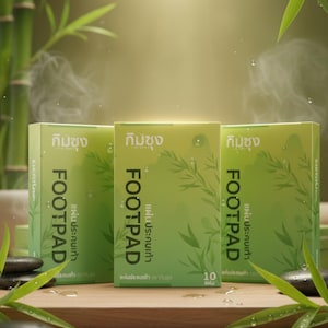 Puede incluir: Tres cajas verdes de almohadillas para los pies se exhiben sobre una superficie de madera. Las cajas tienen la palabra "FOOTPAD" en letras blancas grandes, con texto adicional en un idioma extranjero. El fondo presenta tallos y hojas de bambú.